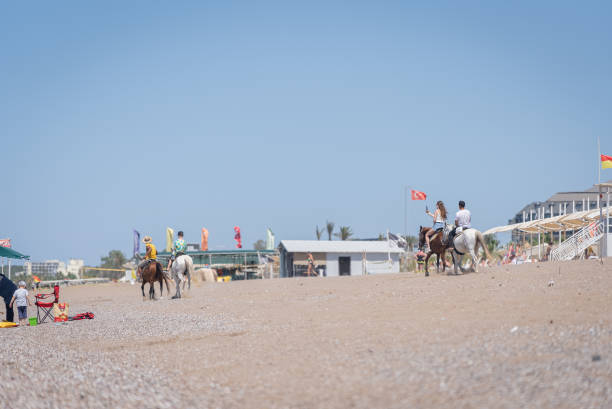 Antalya,Manavgat: Turkey ,Jun 9,2024  Tourists riding horses on the Mediterranean coast by the hotel beach.
