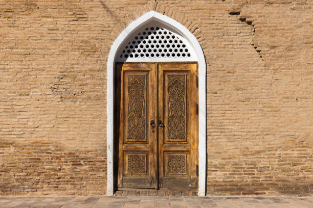 istock Old wooden door with carved white frame and carved Arabic pattern 2160445787