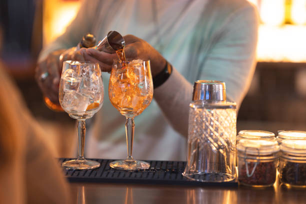 istock A bartender is pouring a drink into two wine glasses 2160447860