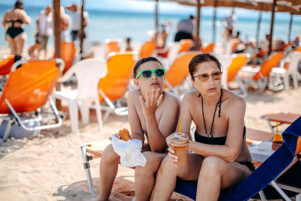Parent spending time together with teenager son on vacation on the beach
