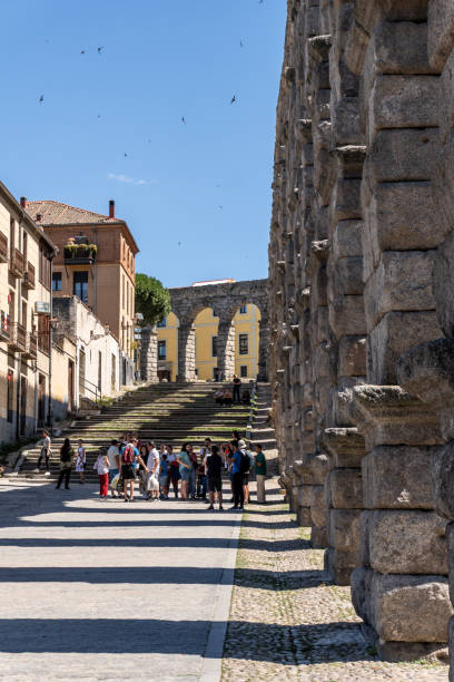 Segovia, Spain. 2 July 2024. Tourists walking at the Segovia Aqueduct, an ancient Roman structure in Spain.