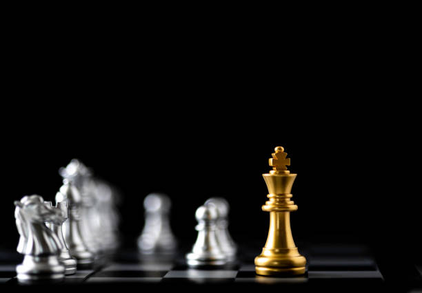 istock Golden king chess stand alone with silver chess on black background. 2160452271