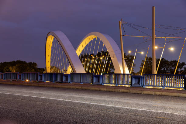 illuminated tram stop with a bridge in Lyon at night