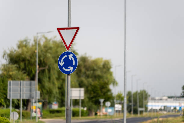 Roundabout and give way traffic signs in summer.