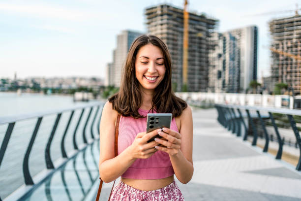 istock Woman using phone on the quayside 2160461139