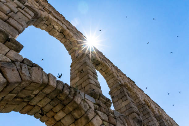 Sun shines over the Segovia Aqueduct in Spain. Ancient Roman architecture.