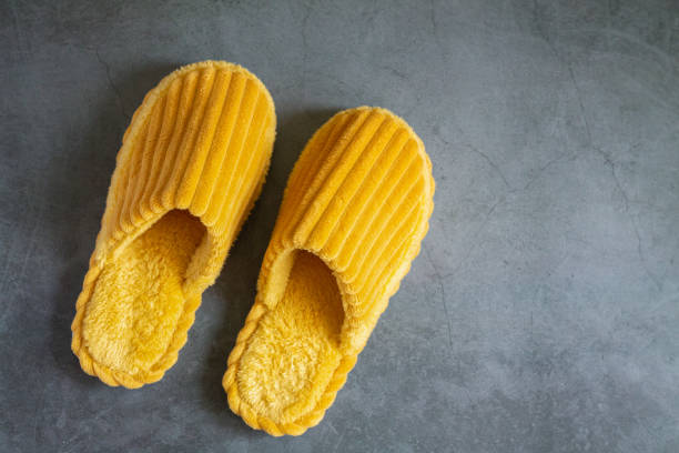 Home fluffy yellow slippers on stone floor