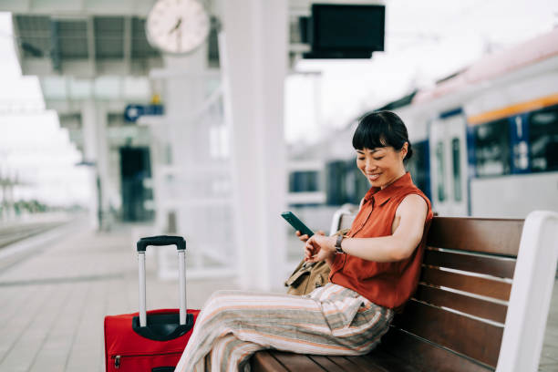 istock Woman Using Phone at Train Station 2160462686