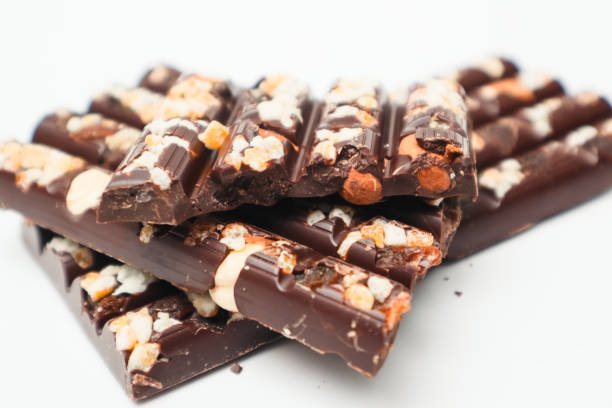 istock Tasty chocolate with nuts. Chocolate pieces with nuts on white background. Selective focus. 2160463569