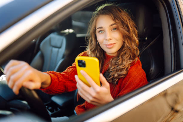 istock Young woman in a car using mobile phone. 2160463979