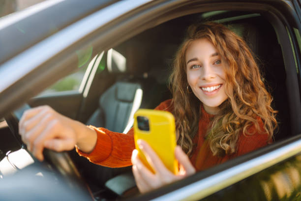 istock Young woman in a car using mobile phone. 2160463980