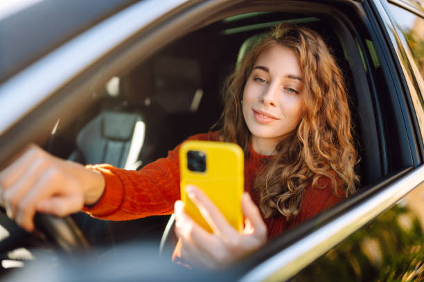 istock Young woman in a car using mobile phone. 2160464198