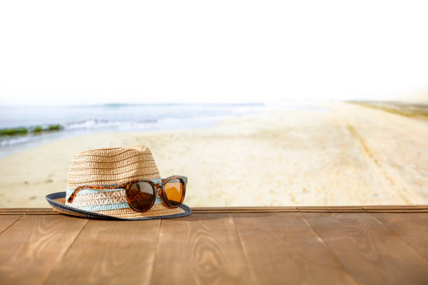 istock Straw hat and sunglasses on wooden table with summer tropical beach  background. Copy space for products. 2160467633