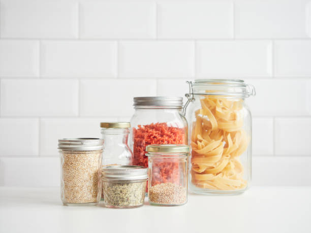 istock different glass jars with lids kitchen pantry containers with dry ingredients for cooking. Quinoa, flax, hemp seeds, dried pasta and spaghetti. 2160470088