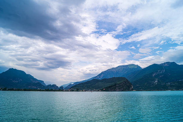 A view of Riva, Lake Garda taken from a ferry as it approaches. The town and Monte Brione can be seen. It was overcast for most of the day, but the clouds were breaking up and the light increasing showing the colours of the water and adding some contrast to the hills surrounding Riva.