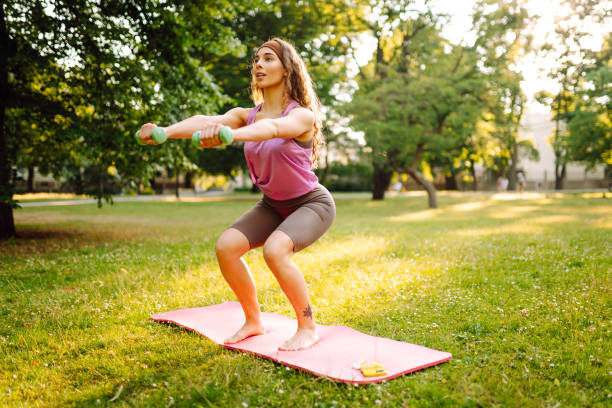 istock Smiling woman practicing and doing exercises on sunny day at park. 2160472021