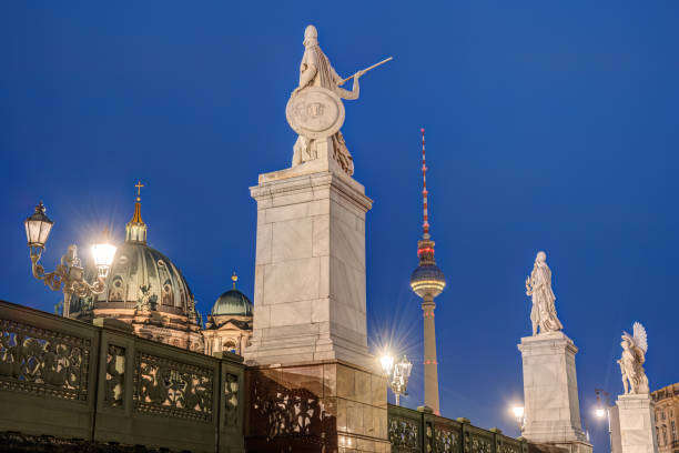Berlin, Germany – December 24, 2025: The Brandenburg Gate illuminated at night with a Pariser Platz street sign visible in the foreground in central Berlin.