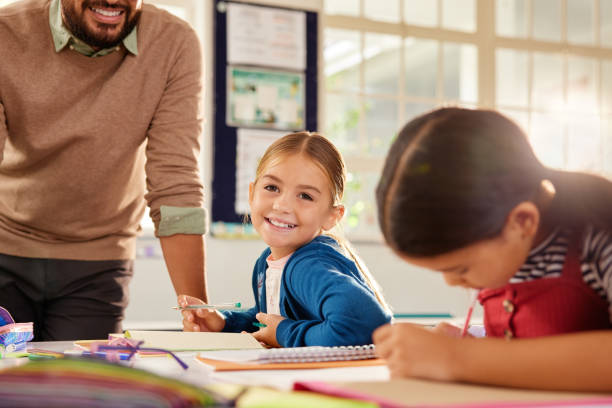istock Portrait of happy smiling elementary girl in class 2160473927