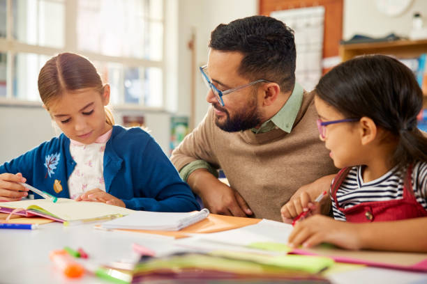 istock Schoolgirl asking doubt to teacher in elementary classroom 2160473943