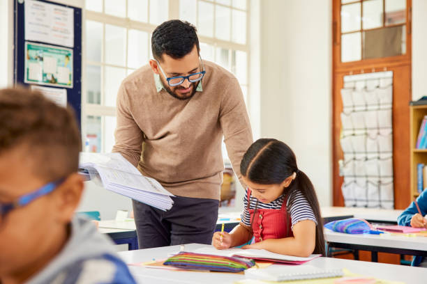 istock Teacher helping student in classroom during lesson 2160474560