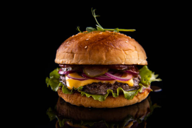 istock Burger with beef, cheese, vegetables on black plate. Dark Background. Close up. 2160475319