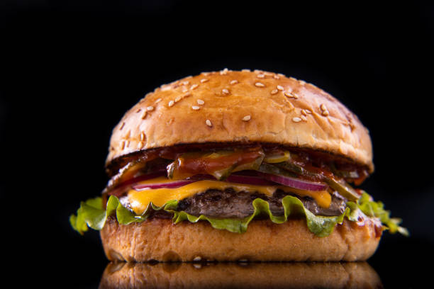 istock Burger with beef, cheese, vegetables on black plate. Dark Background. Close up. 2160475356