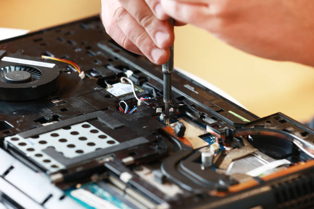 istock Repaiman with screwdriver fixing disassembled laptop parts. Technical support and fixing gadgets problems. Servicing, repairing, cleaning, maintaining computers. Repair shop. Hardware maintenanc 2160478679