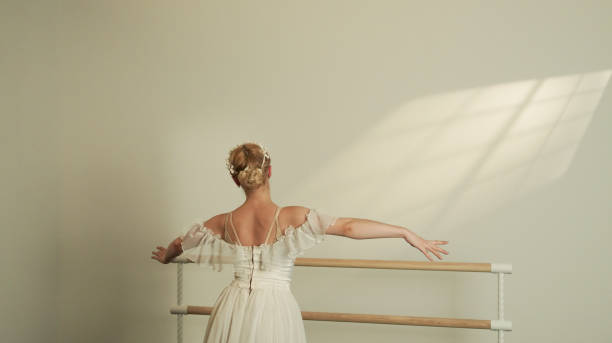 istock Ballet Dancer in White Dress Embracing Light at the Barre 2160478785