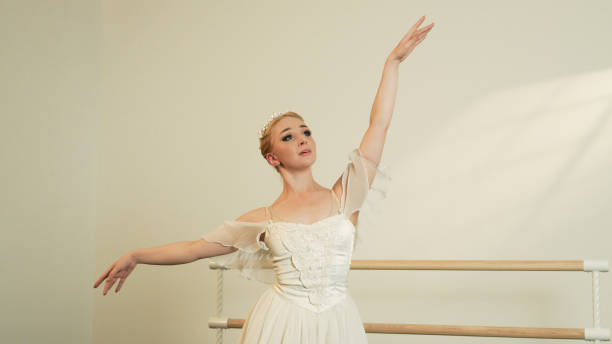 istock Ballet Dancer in Sunlit Studio Performing an Uplifted Pose 2160478891