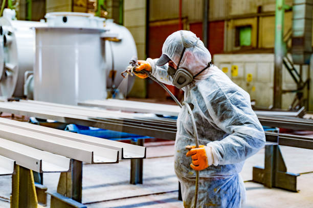 istock A painter is painting a steel surface white 2160479430