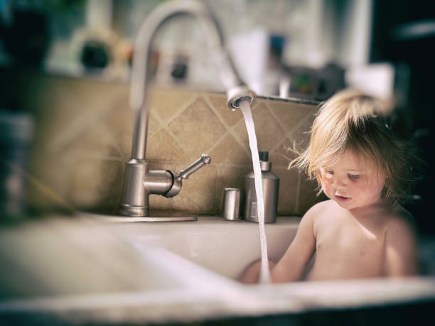 istock Toddler taking a bath in a kitchen sink 2160484092