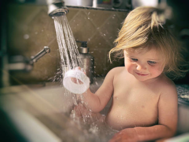 istock Toddler taking a bath in a kitchen sink 2160484097