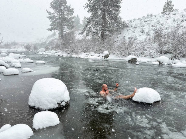 Father cold plunging in the snow and ice