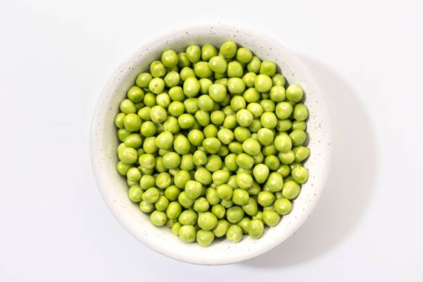 istock Bowl filled with fresh green peas against a white background. 2160485667