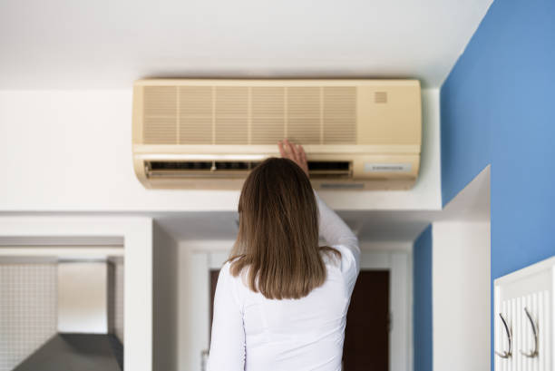 istock Woman controls a smart air conditioner using a remote control on her phone. 2160488880