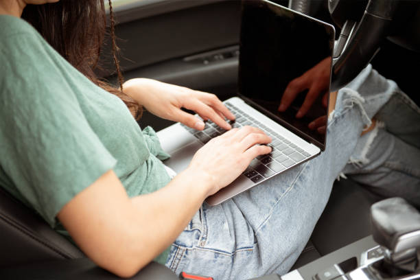 istock Woman browsing laptop in car 2160490081
