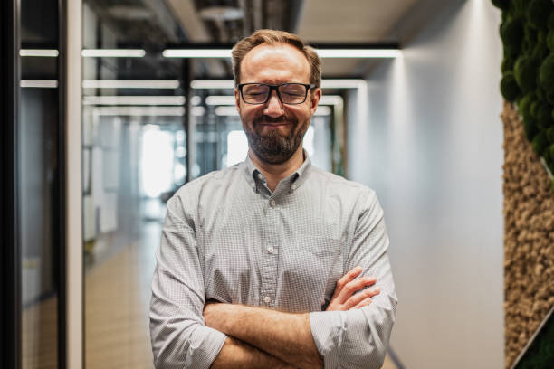 istock Portrait of happy smiling office worker standing in a modern office 2160491408