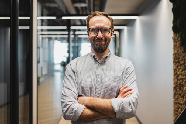 istock Portrait of happy smiling office worker standing in a modern office 2160491426