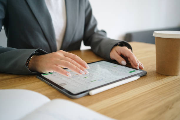 Close-up of a woman's hand interacting with a digital tablet. Unrecognisable businesswoman at her desk in the office.