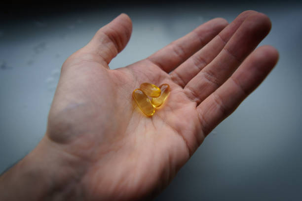 istock Man's hand holding Omega 3 capsule. Close up. High resolution product. 2160497242