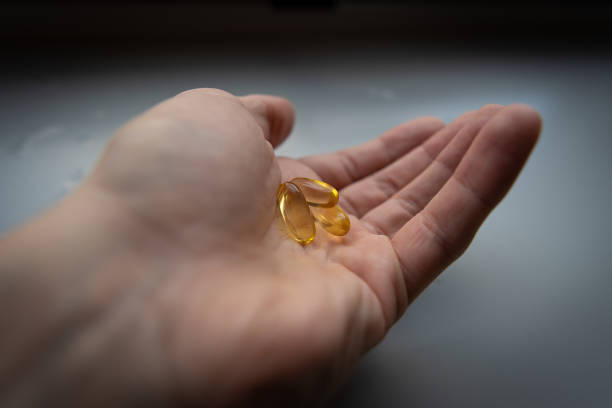 istock Man's hand holding Omega 3 capsule. Close up. High resolution product. 2160497259