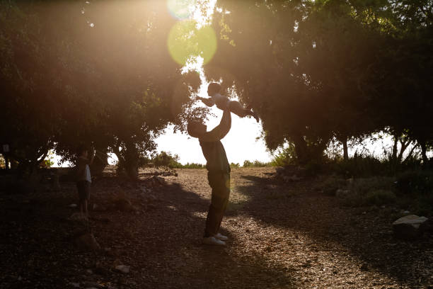 istock Silhouette of father lifting son over head 2160498846
