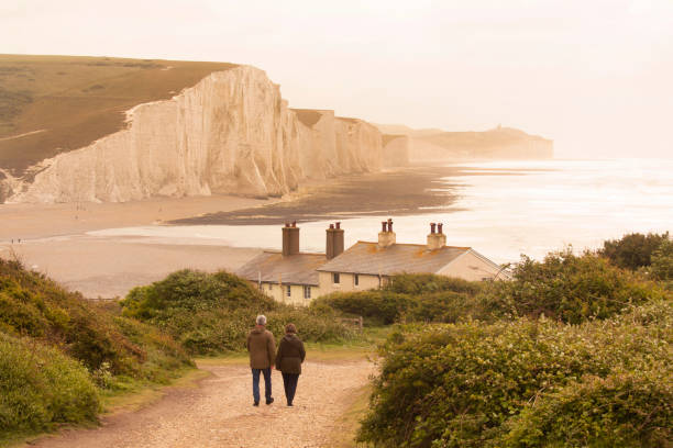 Senior couple walk towards ocean and headlands