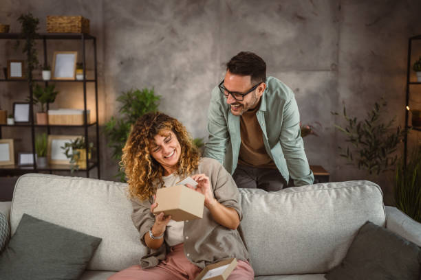 istock Surprised girlfriend hold gift read greeting card from his boyfriend 2160501161