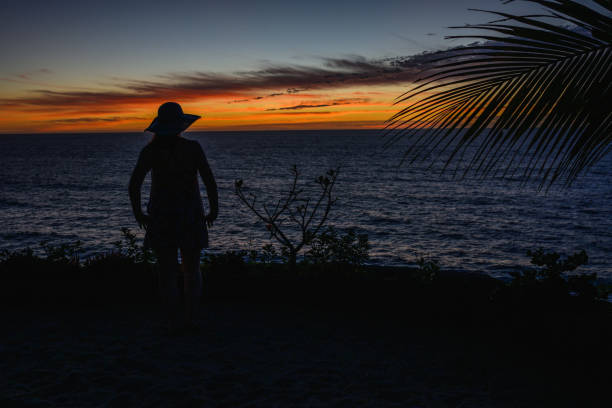 Palm fronds and woman at sunset, San Pancho, Nayarit Riviera