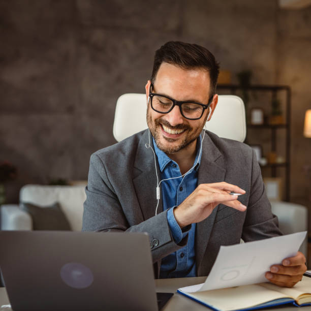 istock man with earphones work from home with girlfriend in the background 2160502580