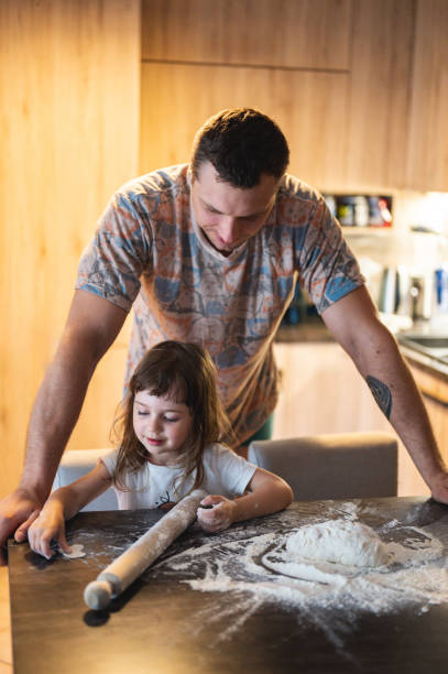 istock little girl baking at home with father. 2160502926