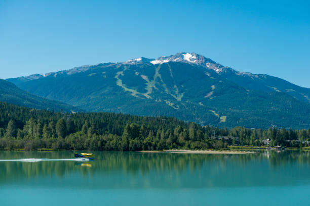 Raised view of mountains and lake with floatplane landing, Whistler, B.C.