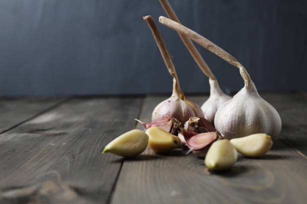 istock Peeled and purple garlic close-up on grey background with space for copy space text. Preparation for cooking 2160503148