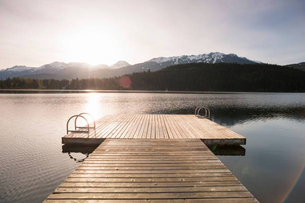 View down pier over lake at sunrise